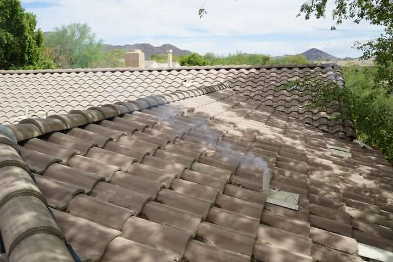 Smoke rising from a roof vent during a rodent entry-point test on a tile roof